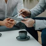 a couple of people sitting at a table with a tablet